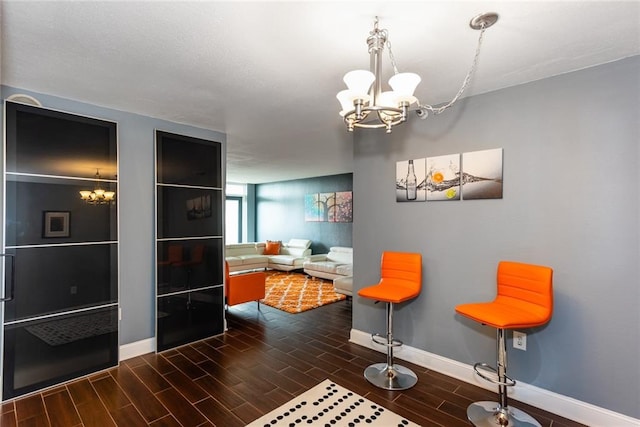 dining space with a chandelier, baseboards, and wood finished floors