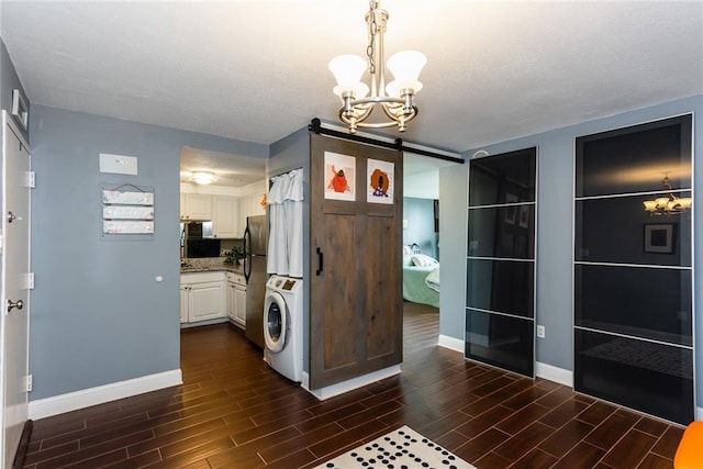 unfurnished dining area with a chandelier, wood tiled floors, baseboards, estacked washer and dryer, and a textured ceiling