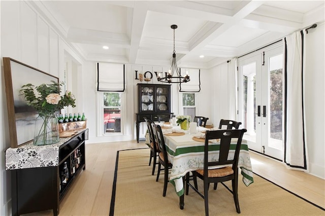 dining space featuring coffered ceiling, beam ceiling, a healthy amount of sunlight, and light wood-style floors