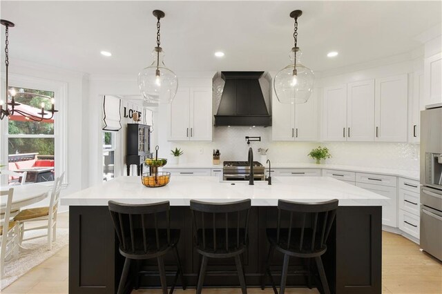 kitchen featuring appliances with stainless steel finishes, open floor plan, white cabinets, and a sink