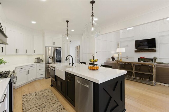 kitchen featuring white cabinets, decorative backsplash, custom exhaust hood, stainless steel appliances, and a sink