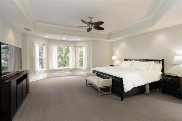 bedroom with carpet, visible vents, a tray ceiling, and crown molding