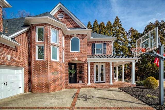 view of front facade featuring french doors, brick siding, and a standing seam roof