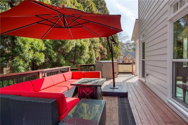 wooden terrace featuring an outdoor living space with a fire pit