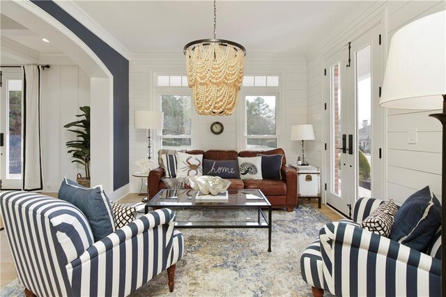 entryway featuring light wood-style floors, a notable chandelier, and a decorative wall