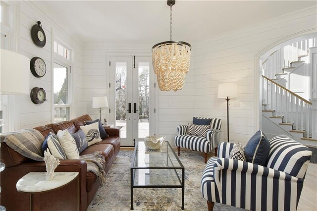 foyer featuring arched walkways, french doors, visible vents, stairway, and hardwood / wood-style flooring