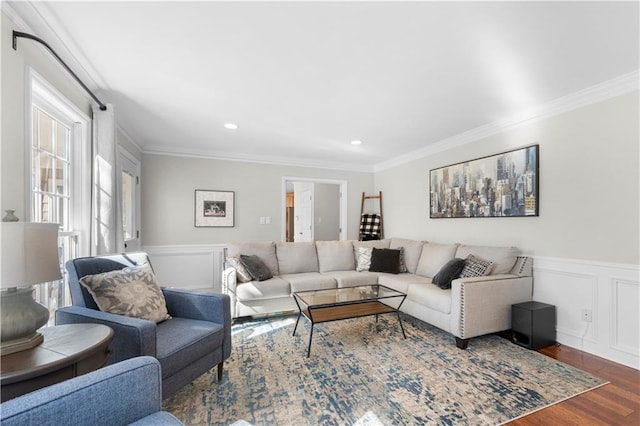 living room featuring dark wood-style floors, ornamental molding, wainscoting, and a decorative wall