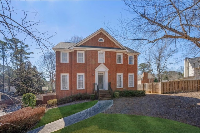 view of front of home with brick siding and fence