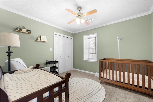 bedroom featuring baseboards, visible vents, light colored carpet, ornamental molding, and a closet