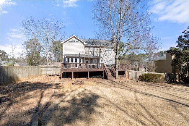 back of house featuring an outdoor fire pit, stairs, a fenced backyard, and a wooden deck