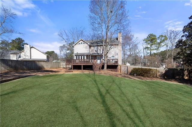 back of house featuring a yard, a fenced backyard, a chimney, and a wooden deck