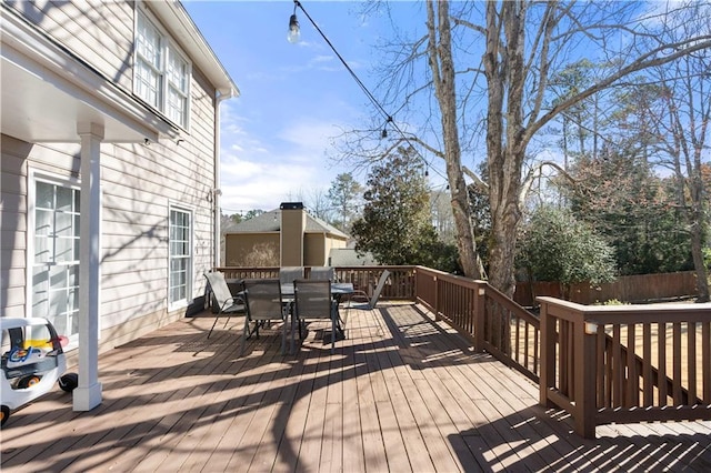 deck featuring outdoor dining space and fence