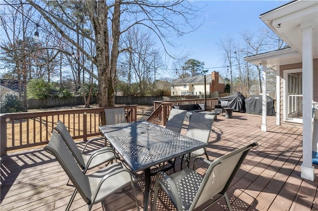 wooden deck featuring outdoor dining area, fence, and area for grilling