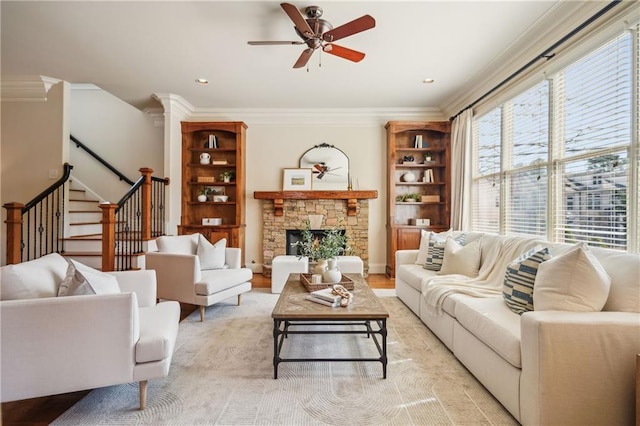 1211 Thornwell Dr, Brookhaven, GA 30319 - living room featuring ornamental molding, ceiling fan, stairway, a stone fireplace, and light wood finished floors
