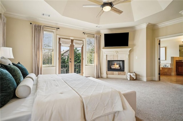 1211 Thornwell Dr, Brookhaven, GA 30319 - carpeted bedroom with a tray ceiling, ornamental molding, a tiled fireplace, connected bathroom, and french doors