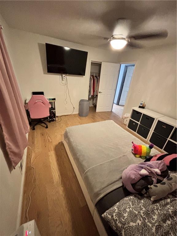 bedroom featuring wood finished floors, a closet, and ceiling fan