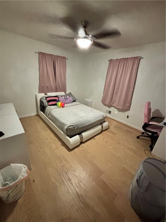 bedroom featuring baseboards, a ceiling fan, and wood finished floors