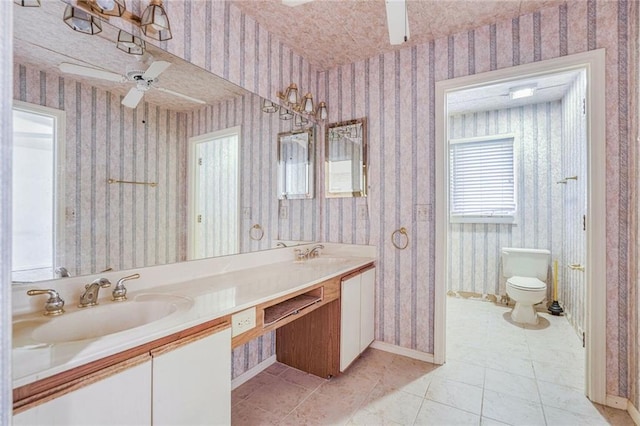 bathroom with ceiling fan, vanity, toilet, and tile patterned floors