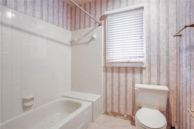 bathroom featuring tiled shower / bath and toilet