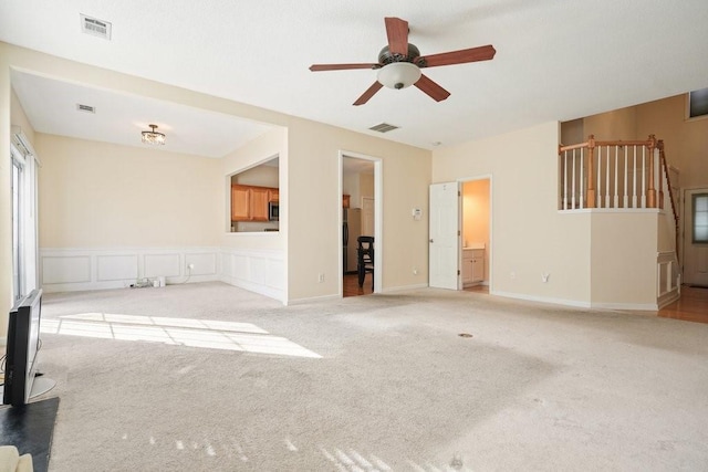 unfurnished living room with ceiling fan and light carpet