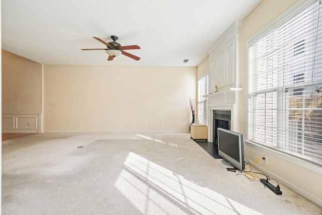 unfurnished living room featuring ceiling fan and carpet