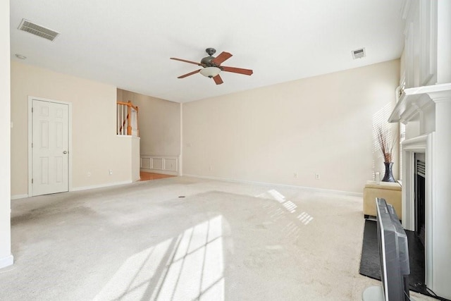 unfurnished living room with light carpet and ceiling fan