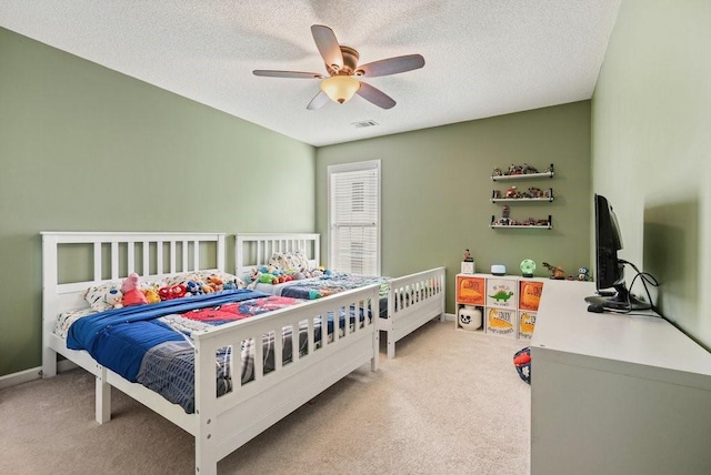 bedroom featuring ceiling fan, light carpet, and a textured ceiling