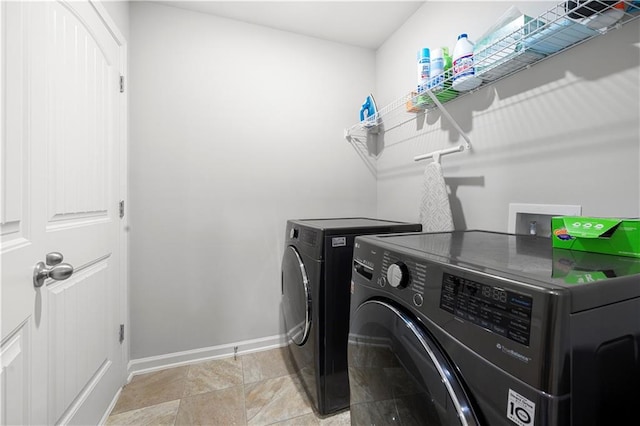 clothes washing area featuring independent washer and dryer and baseboards
