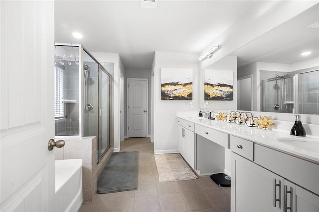 bathroom with a stall shower, double vanity, tile patterned flooring, a garden tub, and baseboards