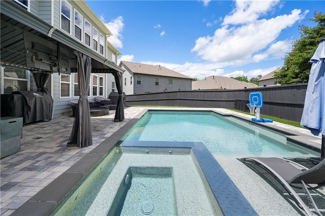 view of swimming pool with a patio, a fenced backyard, and a pool with connected hot tub