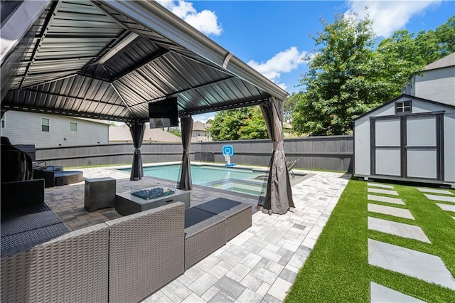 view of patio featuring a fenced backyard, a storage unit, a fire pit, and an outbuilding