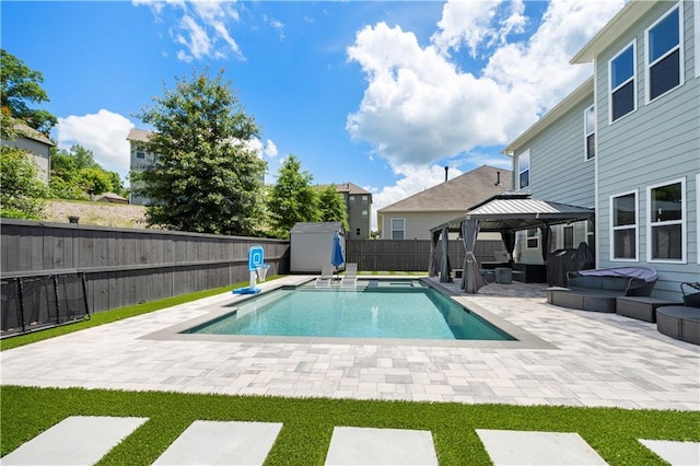 view of pool with a gazebo, a patio area, a fenced backyard, a storage unit, and an outbuilding