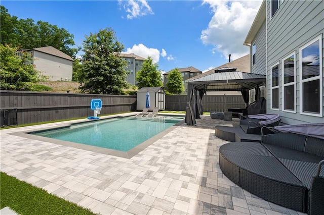 view of pool featuring a patio, a storage unit, a fenced backyard, a gazebo, and an outdoor living space