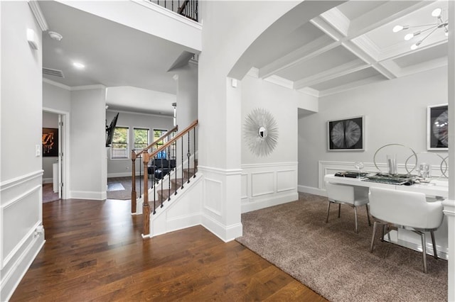 interior space featuring wood finished floors, stairs, beamed ceiling, crown molding, and coffered ceiling