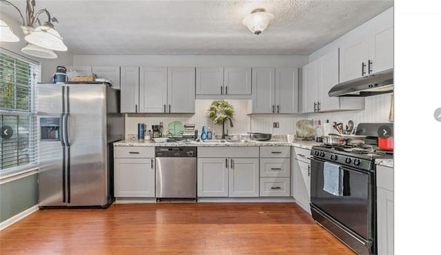 kitchen with tasteful backsplash, stainless steel appliances, sink, and light wood-type flooring