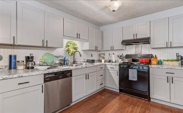 kitchen featuring dishwasher, sink, white cabinets, gas stove, and dark wood-type flooring