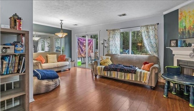 living room with dark wood-type flooring, ornamental molding, and a textured ceiling