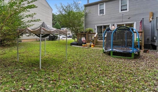 view of yard featuring a trampoline and central air condition unit