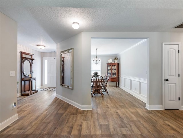 132 Mcmillian Ct, Winder, GA 30680 - entryway with wood finished floors, a chandelier, wainscoting, baseboards, and a textured ceiling
