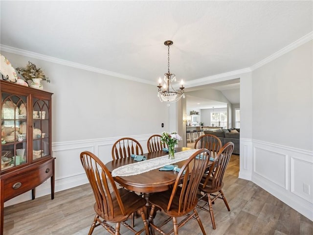 132 Mcmillian Ct, Winder, GA 30680 - dining space featuring a chandelier, light wood-style floors, ornamental molding, wainscoting, and a decorative wall