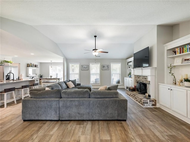 132 Mcmillian Ct, Winder, GA 30680 - living area with lofted ceiling, a ceiling fan, wood finished floors, and a fireplace