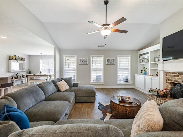 132 Mcmillian Ct, Winder, GA 30680 - living room featuring lofted ceiling, ceiling fan, wood finished floors, baseboards, and a brick fireplace