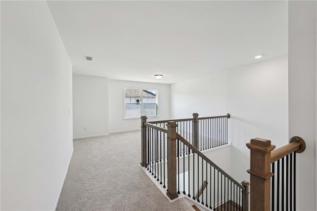 hallway featuring light colored carpet