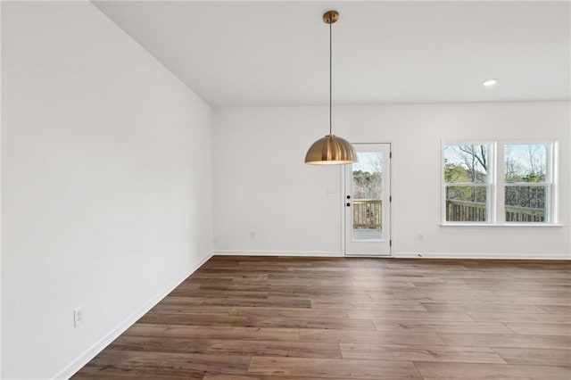 unfurnished dining area with dark wood-type flooring