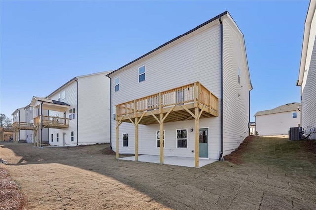 rear view of house with cooling unit, a lawn, a deck, and a patio area