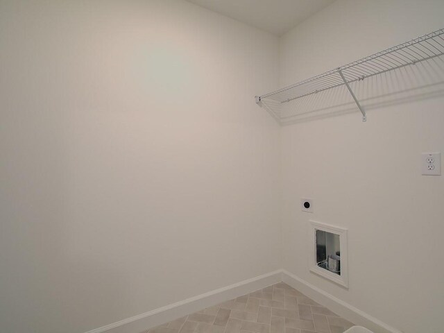 laundry room featuring electric dryer hookup and light tile patterned flooring