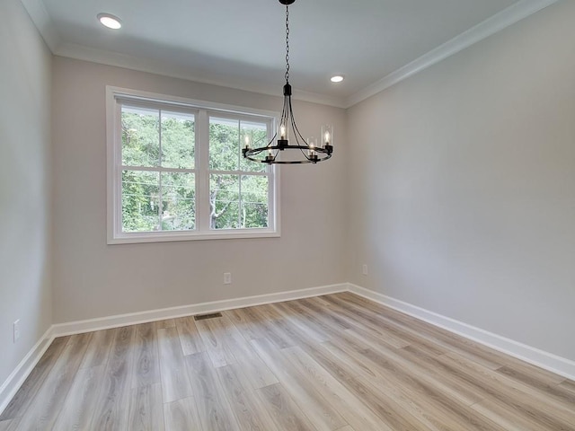 unfurnished dining area with light hardwood / wood-style flooring, an inviting chandelier, and crown molding