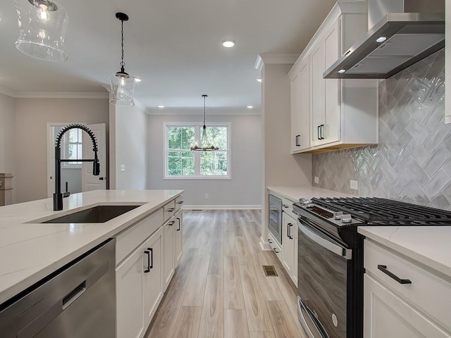 kitchen featuring dishwasher, white cabinetry, range with gas stovetop, sink, and wall chimney exhaust hood