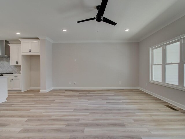 unfurnished living room with light hardwood / wood-style floors, ornamental molding, and ceiling fan