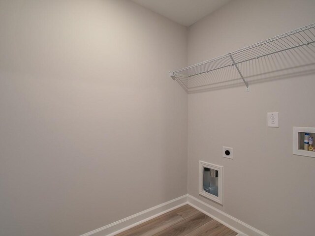 washroom with hookup for an electric dryer, light hardwood / wood-style floors, and washer hookup